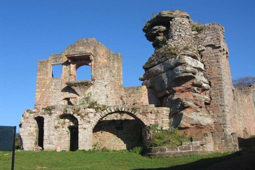 A historical stone structure with arches and a tower.