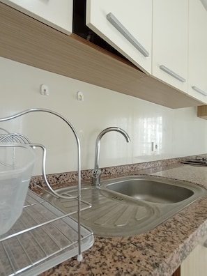 A kitchen with a granite countertop, stainless steel sink, and modern cabinetry. - Antalya Bed & Breakfast (Konyaalti)
