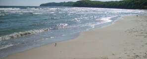 Ein Strand mit sandigem Ufer und Meereswellen.