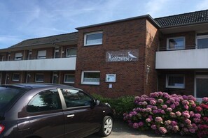 A building with a sign reading 'Kiebitzwiese' and a parked car in front. - 4 in the Kiebitzwiese house (Borkum)