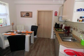 Una cocina compacta con comedor, una puerta y un lavamanos pequeño.