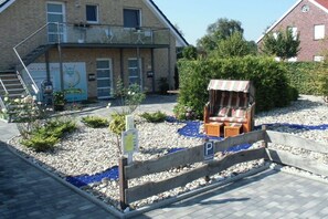 Ein Gebäude mit einer Treppe, einem überdachten Sitzbereich und einem Parkschild.