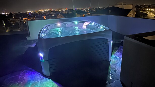 Een jacuzzi op een dak met een stadsgezicht op de achtergrond.