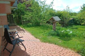 A patio area with brick flooring and outdoor furniture. - in the middle of an organic fruit farm (Elbinsel Krautsand)