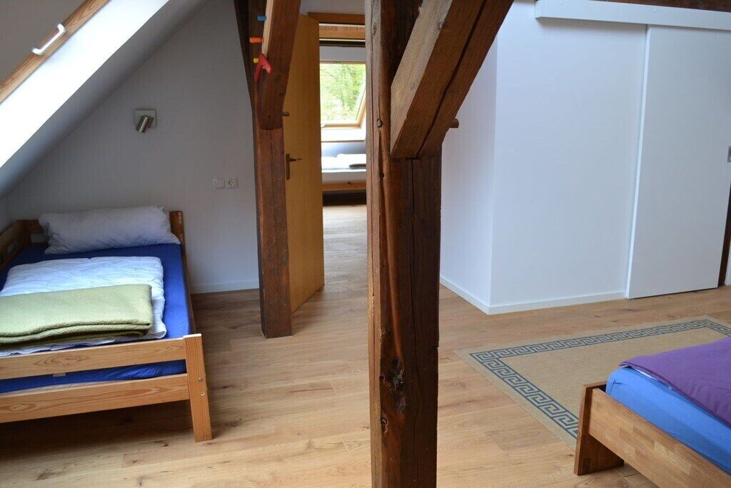 Una habitación con dos camas de madera, un tragaluz y vistas al exterior.