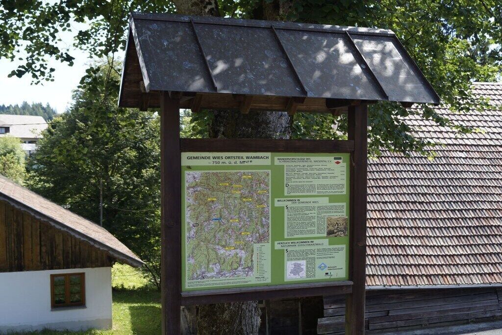 A wooden structure with a solar panel roof, a map, and informational text.