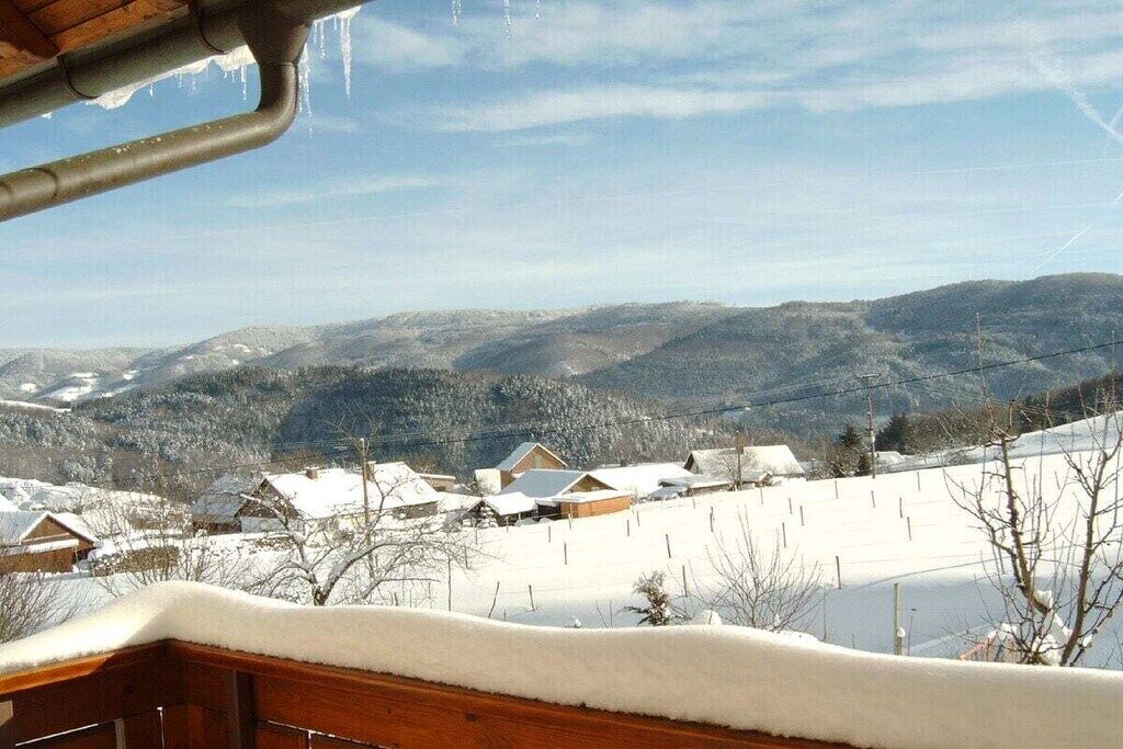 Un paisaje nevado con casas y montañas al fondo.