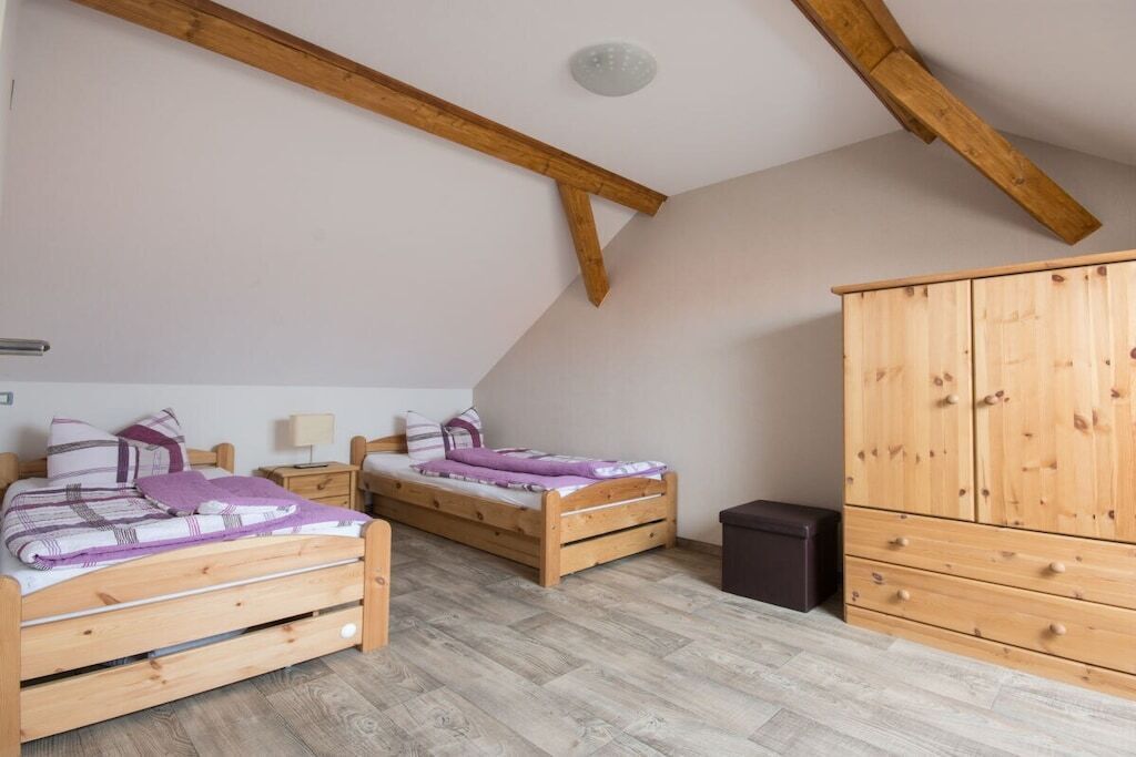Un dormitorio con dos camas de madera, un armario y un pequeño cubo de basura.