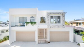 A modern two-story house with a garage, large windows, and a stone facade. - Your Buddina Escape:Swim, Sip & Unwind by the Pool (Buddina)