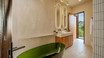 A modern bathroom with a green bathtub, a vanity with a mirror, and a view of the outdoors.