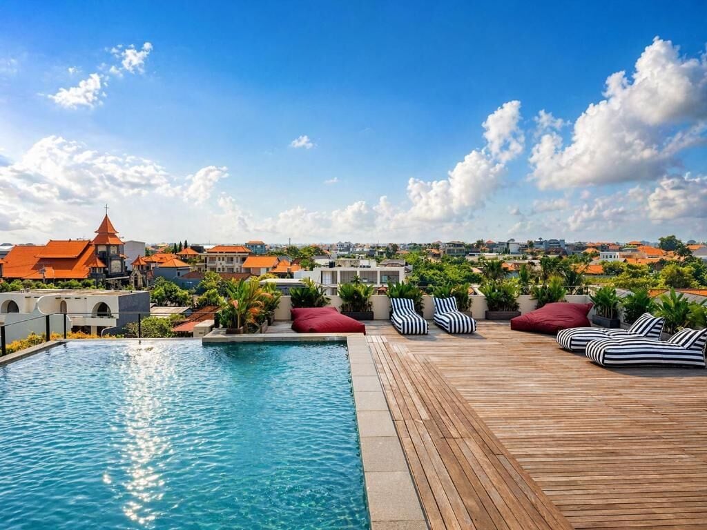 A rooftop pool area with lounge chairs and a view of the cityscape.