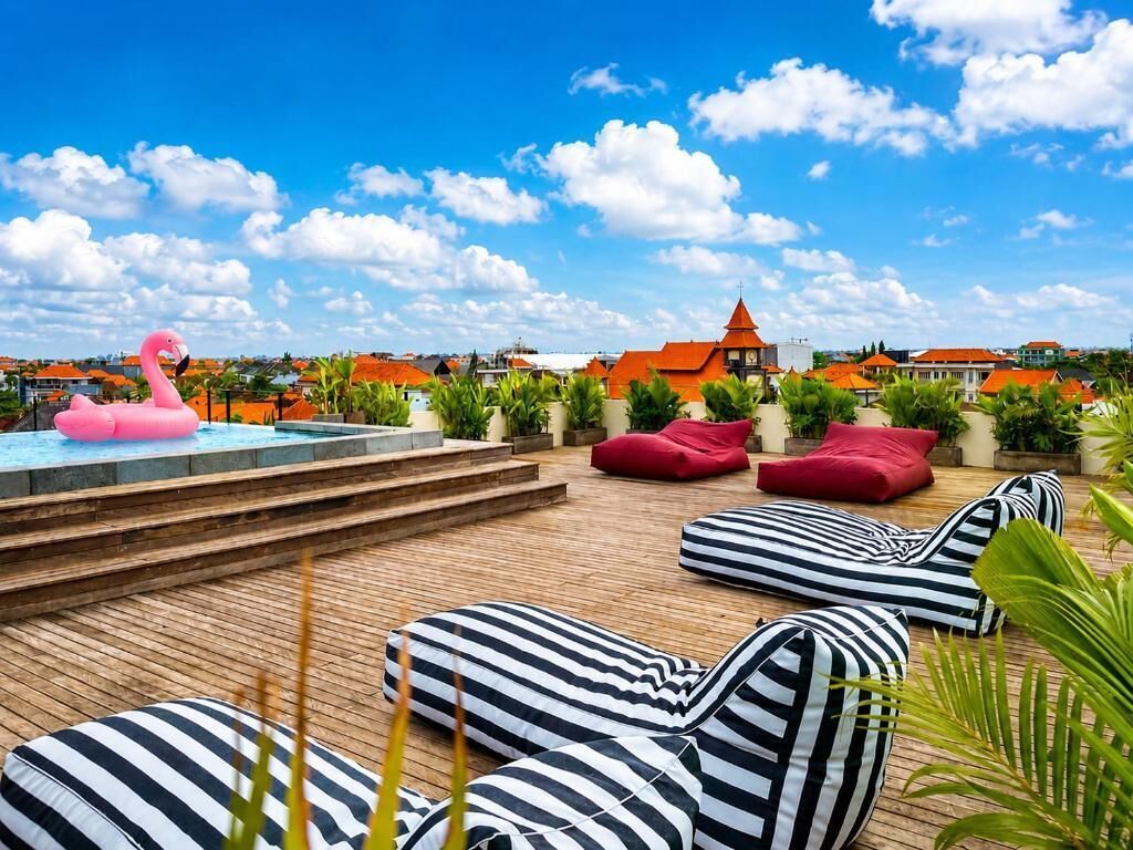 A rooftop pool area with lounge seating and a pink flamingo decoration.