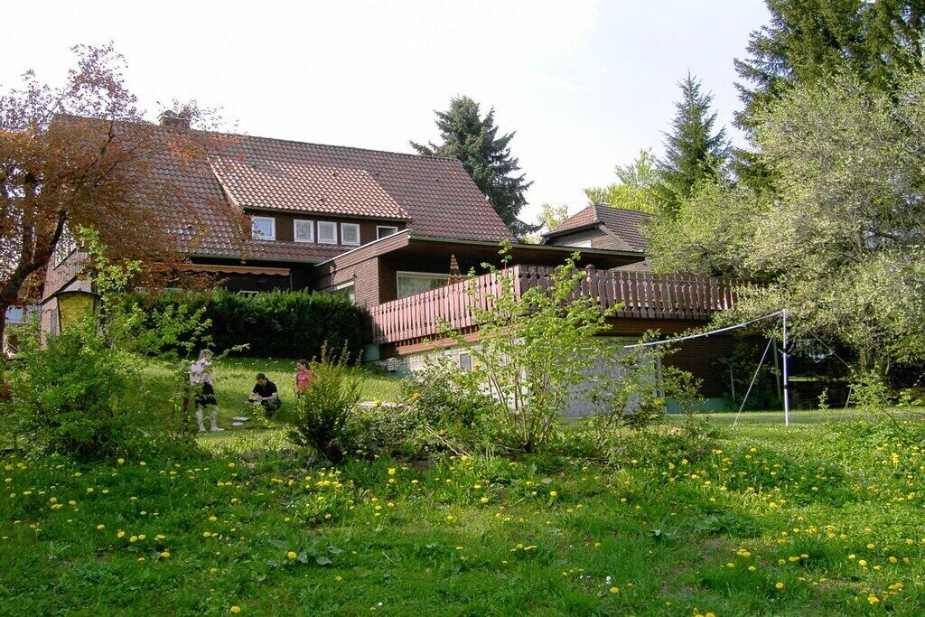 A two-story house with a fenced yard and a wooden deck.