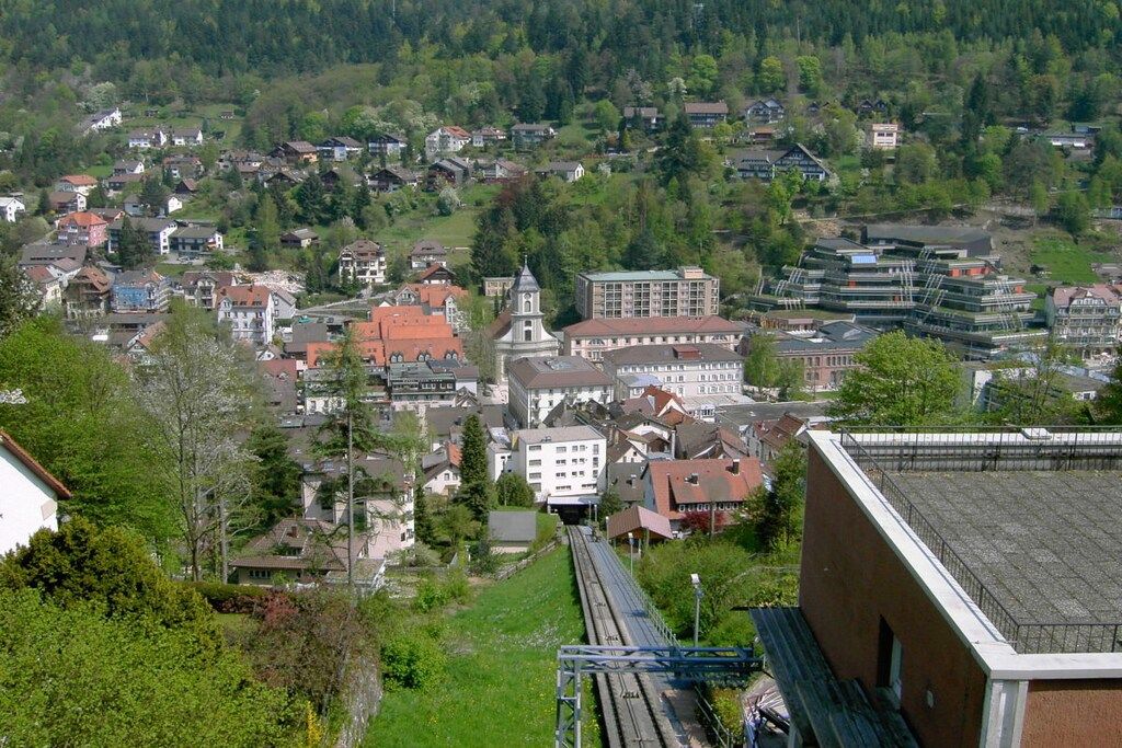 A town with a mix of residential and commercial buildings, a prominent church, and a railway track.