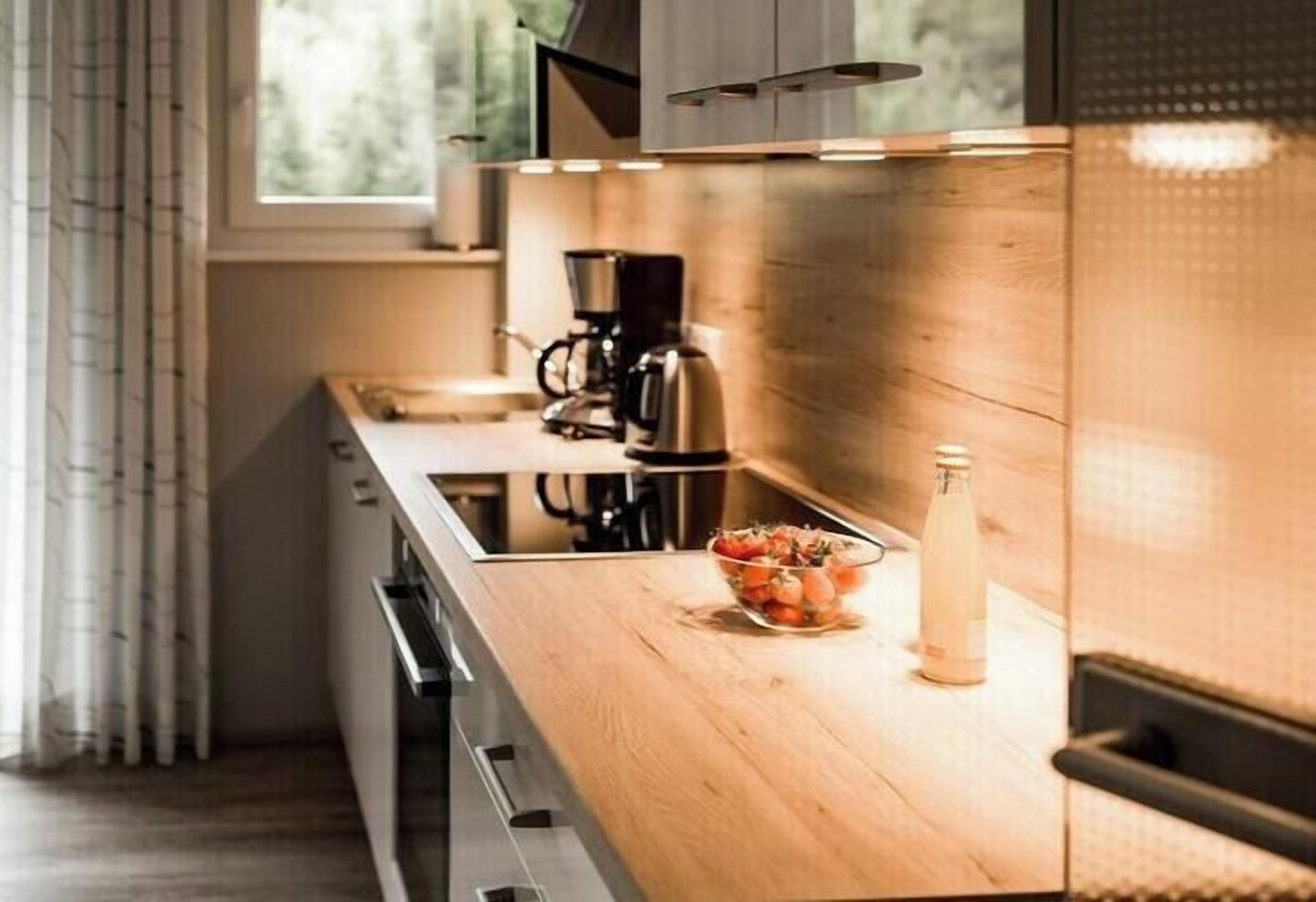 Una cocina moderna con encimera de madera, electrodomésticos de acero inoxidable y un bol de fruta.