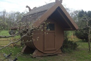 A small wooden structure with a sloped roof, a door, and a window. - Forester's Lodge Apartment Tawny Owl (Burg)