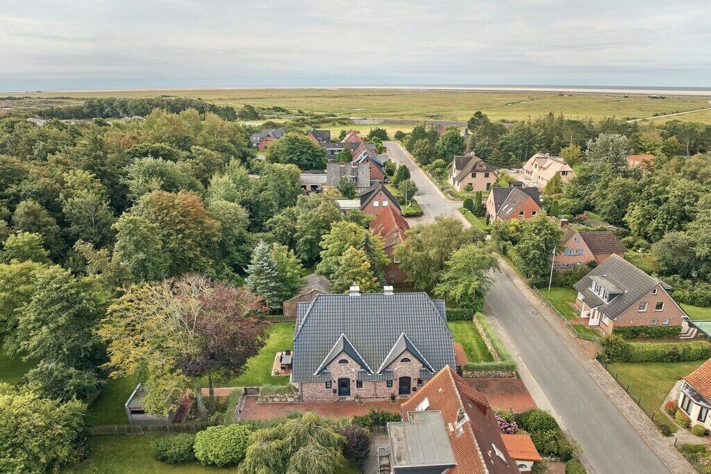 A residential area with houses, a road, and a large open field in the background.