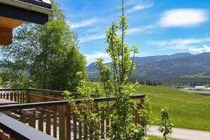 Une terrasse en bois offrant une vue sur un paysage montagneux.