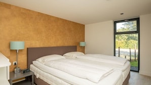Ein Hotelzimmer mit einem großen Bett, Nachttischen und einem Fenster mit Blick.