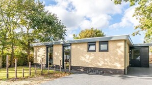 Ein modernes Gebäude mit Ziegelaußenwand, großen Fenstern und flachem Dach.