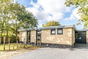 A modern building with a brick facade, large windows, and a flat roof. - Holiday home in Renesse with swimming pool (Renesse)