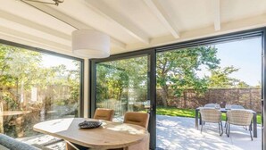 Ein modernes Interieur mit einer Glastür, die auf eine Außenpatio führt.