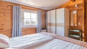 Ein Schlafzimmer mit einem Bett, einem Kleiderschrank und einem fenster mit Vorhängen.