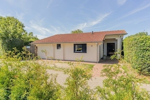 A single-story building with a tiled roof, a front door, and a small porch area. - Holiday home in Renesse with swimming pool (Renesse)