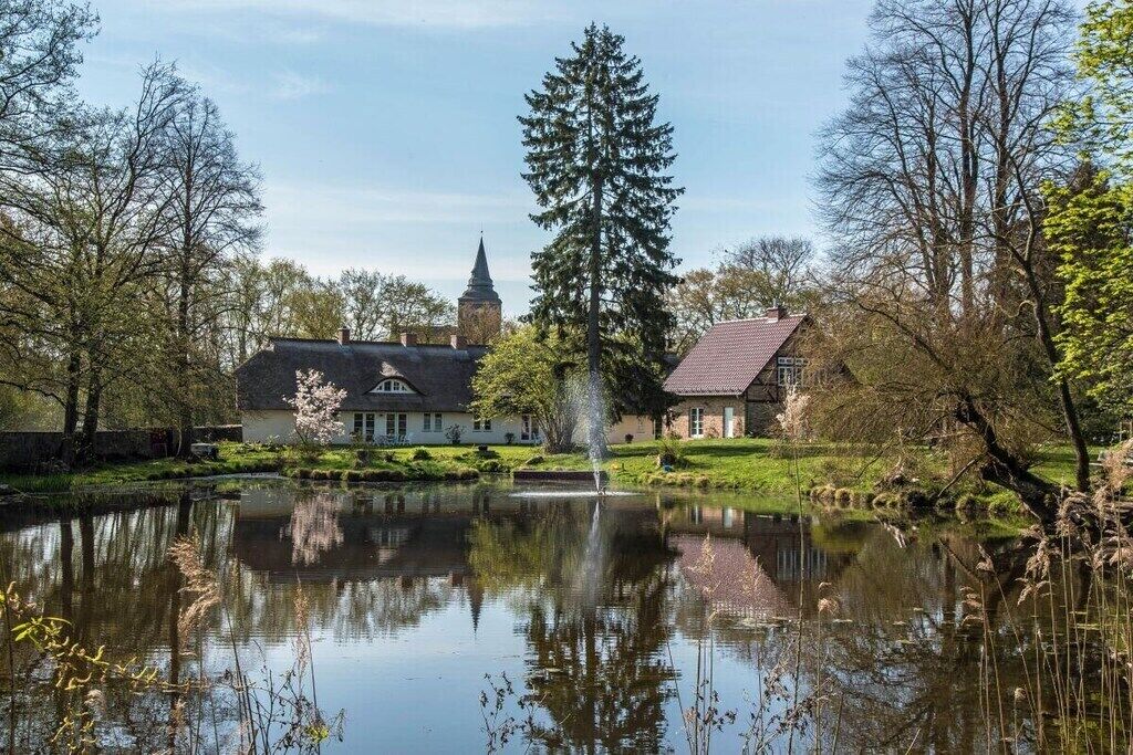 Eine friedliche Seelage mit einem traditionellen Gebäude, einem Kirchturm und einem gepflegten Rasen.