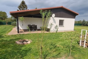 A modern single-story house with a covered patio, a satellite dish, and a small garden area. - Bungalow in Priepert with swimming pool (Priepert)