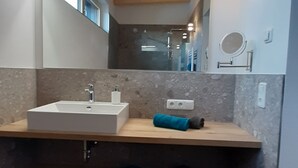 Ein modernes Badezimmer mit großem Spiegel, zwei Waschbecken und einem Handtuchhalter.
