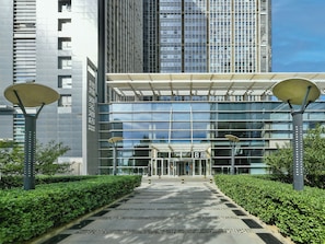 A modern building with a glass facade, a clear entrance, and a well-maintained pathway leading to the entrance. - BEIJING GOOHUG HOTEL (Beijing)