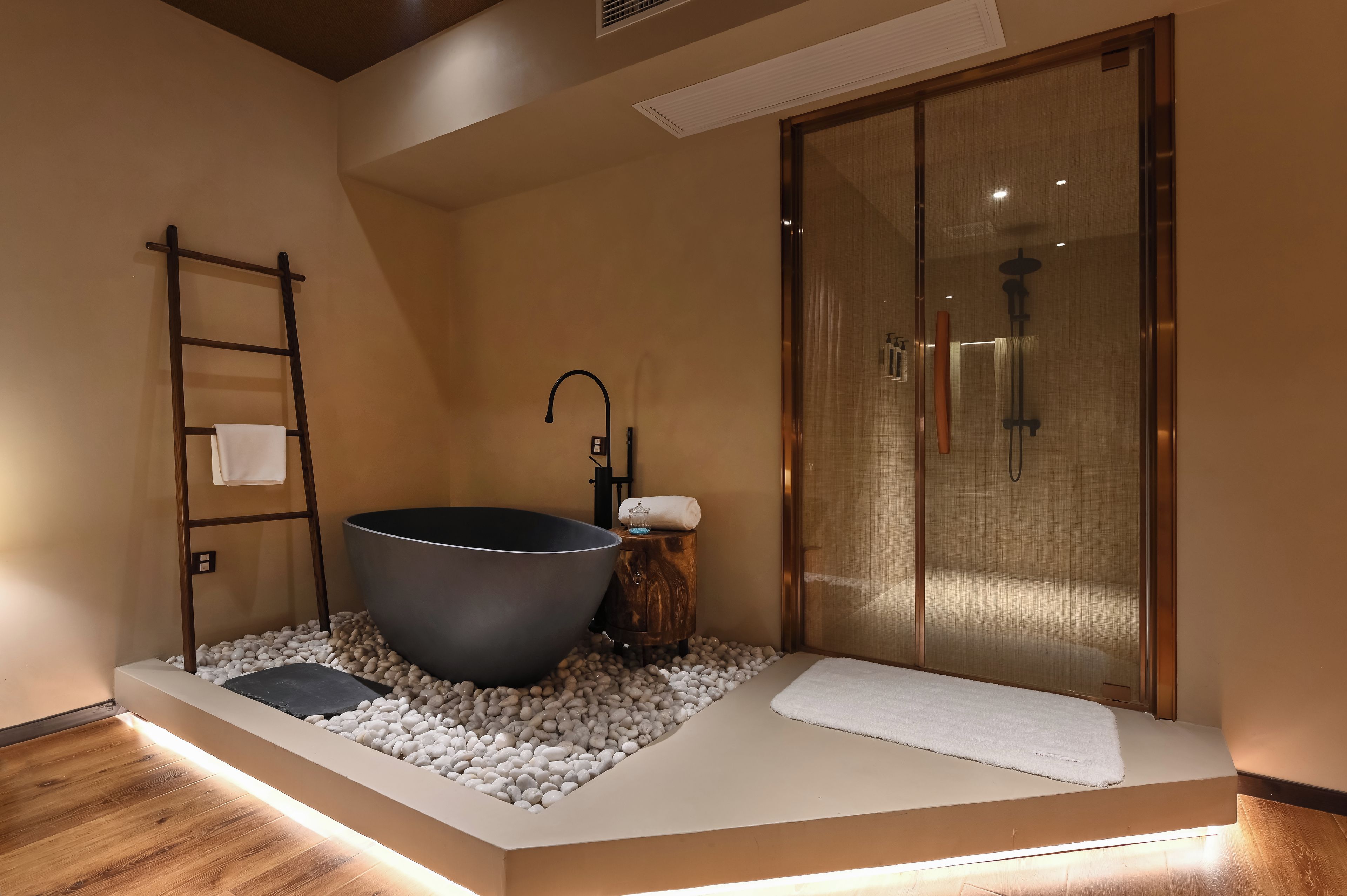 Un baño con una bañera grande, ducha y escalera de madera.