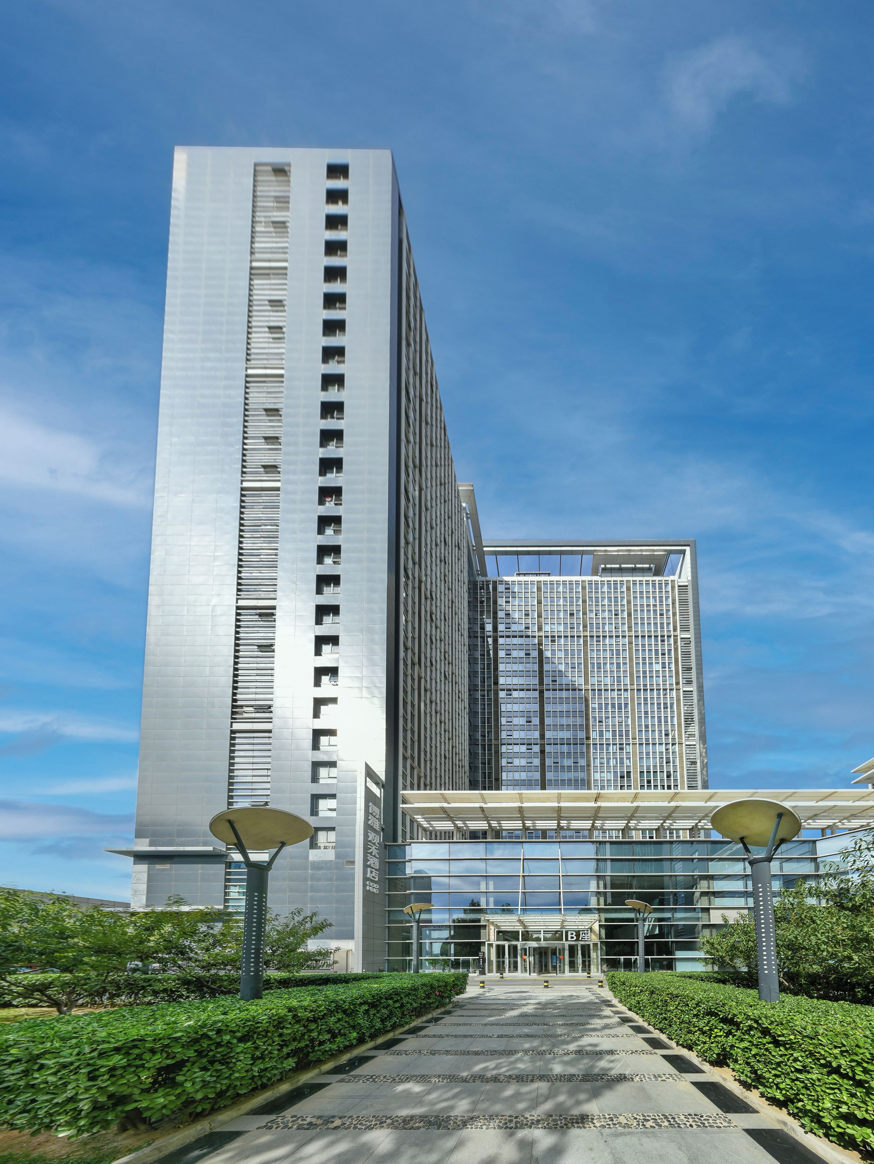A modern building with a glass facade and a clear sky.