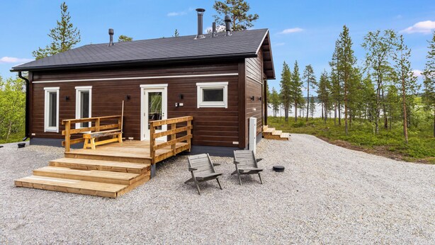 A cabin with a wooden exterior, a porch with wooden steps, and a gravel driveway. - Villa goskanjavri by Interhome (Inari)