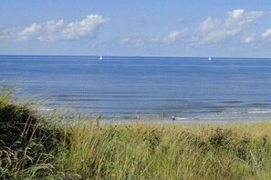 A beach with clear skies, calm water, and distant sailboats. - Holiday apartment with 2 bedrooms (Callantsoog)