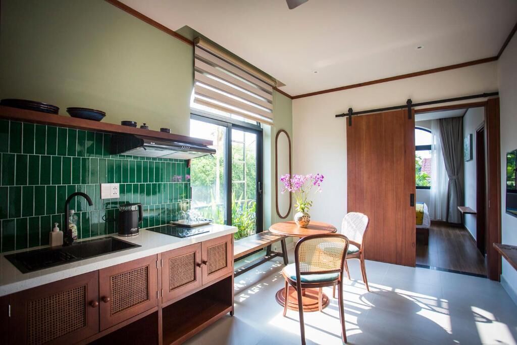 Una cocina moderna con un lavamanos, armarios y una ventana con vistas a la vegetación.