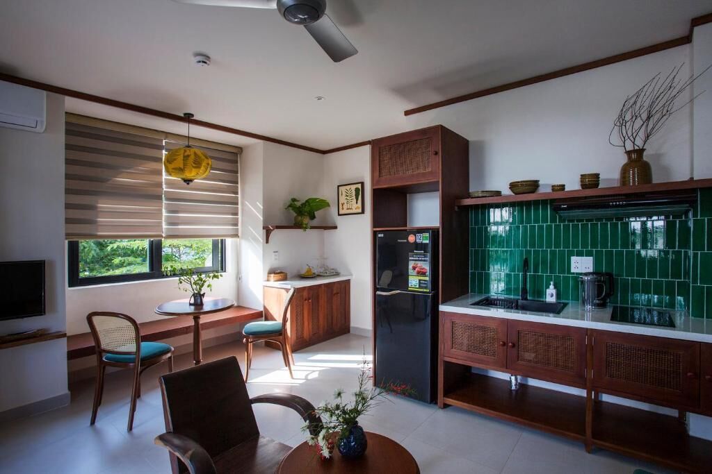 A modern kitchen with a built-in refrigerator, wooden cabinets, and a green tiled backsplash.