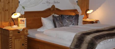 Una cama de madera con dosel, dos lámparas de noche y una pared con una frase decorativa.
