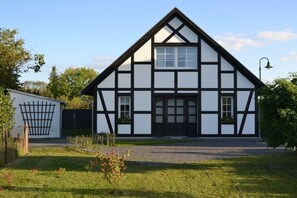 A traditional half-timbered house with a symmetrical facade, a central door, and a small window on the upper floor. - Holiday home with 2 bedrooms (Letschin OT Gross Neuendorf)