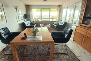 Ein Wohnzimmer mit einer Sofagarnitur, einem Couchtisch und einem Fernseher.