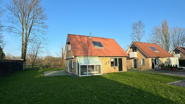Ein Wohngebiet mit zwei Häusern, jedes mit geneigtem Dach und einer Veranda.
