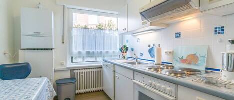 A compact kitchen with a built-in oven, a stove, and a sink.