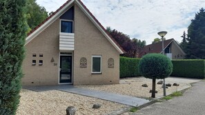 A single-story house with a sloped roof, a front door, and a small window.