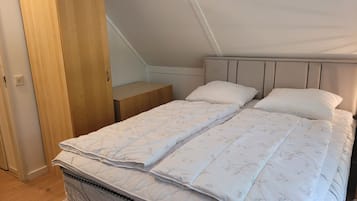 Un dormitorio con cama, mesita de noche y armario de madera.