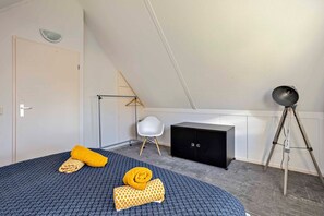 Une chambre à coucher comprenant un lit, une armoire, un bureau et une lampe sur pied.