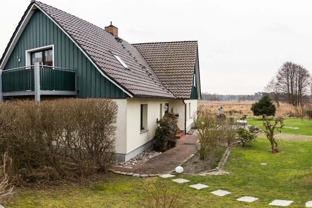Una casa de un solo piso con techo inclinado, una chimenea a la vista y un pequeño porche.