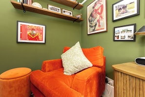 Ein Zimmer mit einer Couch, einem kleinen Tisch und gerahmten Bildern an den Wänden.