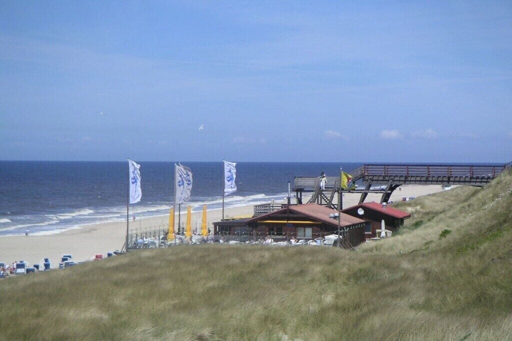 A beachside view with a building, flags, and the ocean.