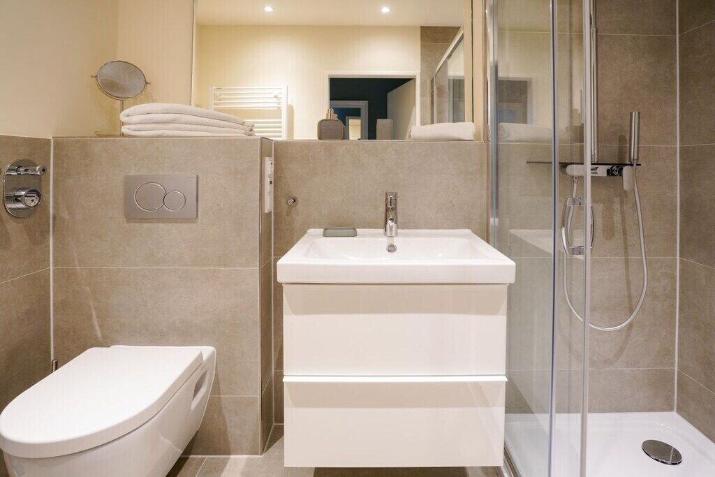A modern bathroom with a toilet, a sink, and a shower enclosure.
